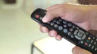 Two college girls having fun with a guy using the remote control