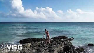A fit girl is playing on the naked beach, showcasing her sexy body