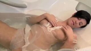 A lonely brunette woman caresses herself in the shower with her fingers