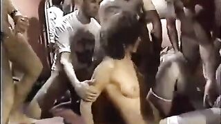 A young whore in stockings is having fun with a bunch of guys