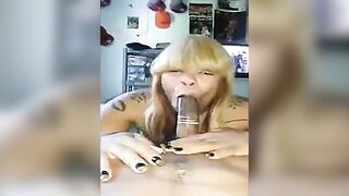 A black woman has a big dick in her mouth wrapped in a condom