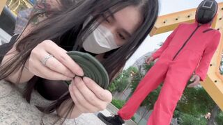 Asian beauty participates in a squid game, showcasing her skills and charm