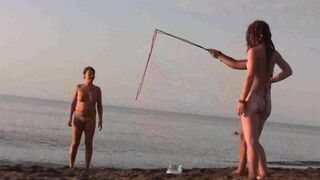 A naked girl is having fun on the beach in public