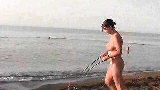 A naked girl is having fun on the beach in public