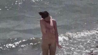 A couple of free-spirited lovers have fun on a naked beach