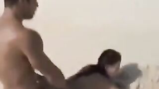 A naked girl is having fun on the beach with her companion