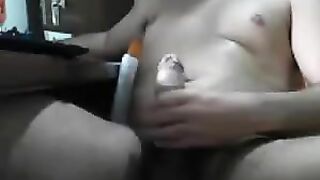 A guy sits at the computer and masturbating his dick with his hand