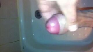 The kid caresses his dick under the jet of water in the shower