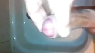The kid caresses his dick under the jet of water in the shower