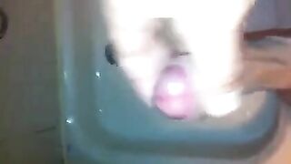 The kid caresses his dick under the jet of water in the shower