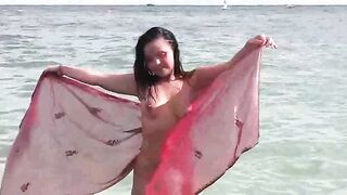 A hot naked girl is having a bath in the sea