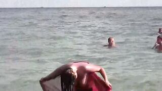 A hot naked girl is having a bath in the sea