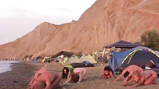 A group of naked people play volleyball on the beach in HD