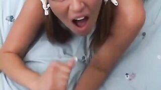 A hot young blonde with glasses gets fucked on the bed in doggy style