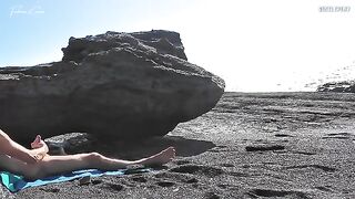 A girl removes her swimsuit and rubs herself while her friend jerks off on the beach