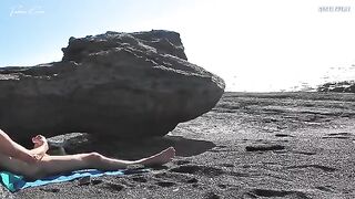 A girl removes her swimsuit and rubs herself while her friend jerks off on the beach